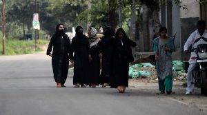 A group of muslim women walk down a road in Amroha, Uttar Pradesh.