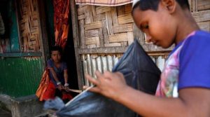 opA Rohingya boy looks on as another boy makes a kite in Leda unregistered Rohingya Refugee Camp in Cox’s Bazar